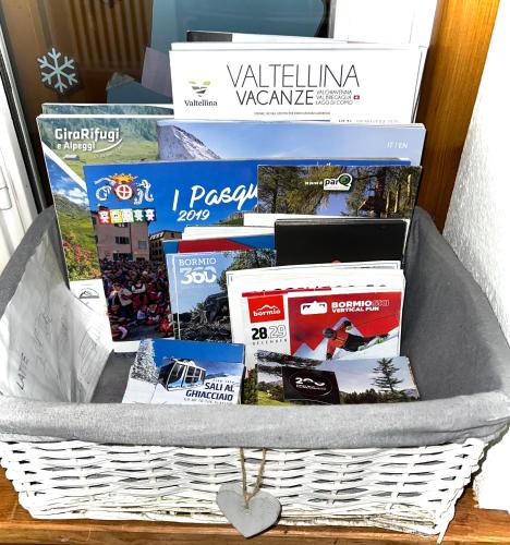 a basket filled with magazines and books on a table at CASA CARCENTINA giardino, Pass zona rossa, Pista Olimpiadi Stelvio 2026 in Bormio