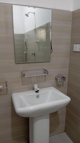 a bathroom with a white sink and a mirror at Leaf Dew Resort in Anuradhapura