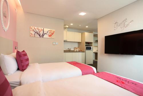 a hotel room with two beds and a flat screen tv at Hotel Skypark Kingstown Dongdaemun in Seoul