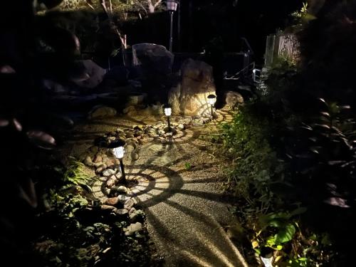 a garden at night with lights on the path at 伊勢ブルーヴィラ本館と離れ in Ise