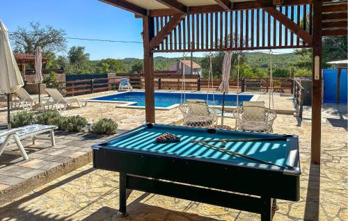 a pool table in front of a swimming pool at Nice Home In Benkovac in Benkovac
