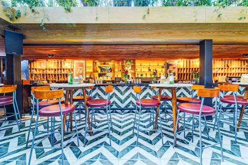 a bar with colorful stools in a restaurant at HOTEL THE SLATE Near APOLLO HOSPITAL & US EMBASSY in Chennai