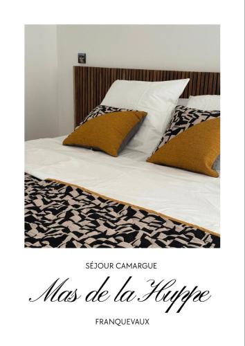 a bed with two pillows on it with the wordslas be la hype at Mas de la Huppe - Franquevaux en Petite Camargue in Beauvoisin