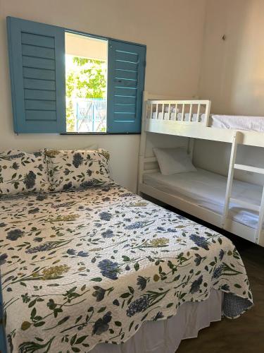 a bedroom with a bed and a bunk bed at Chalé brilho do mar in Icapuí