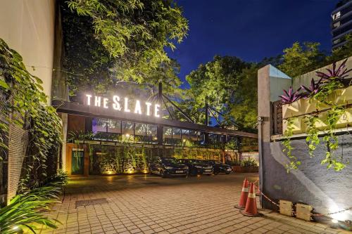 a building with cars parked outside of it at night at HOTEL THE SLATE Near APOLLO HOSPITAL & US EMBASSY in Chennai