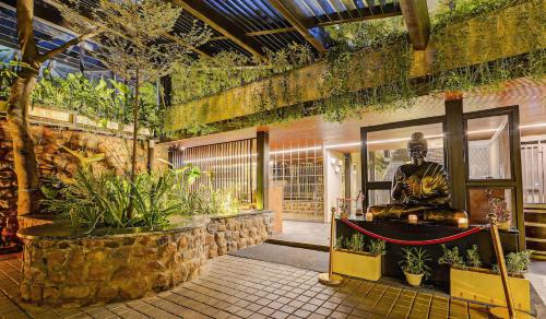 a lobby with a statue in a building with plants at HOTEL THE SLATE Near APOLLO HOSPITAL & US EMBASSY in Chennai