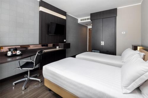 a hotel room with two beds and a desk and a chair at Best Western Premier CHC Airport in Genova