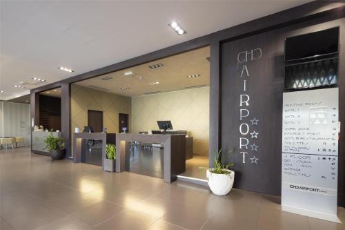 an office lobby with a reception area with plants at Best Western Premier CHC Airport in Genova