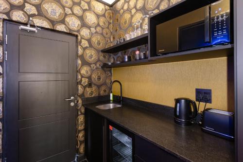 a kitchen with a sink and a microwave and a door at Mint Hotel Rosebank in Johannesburg