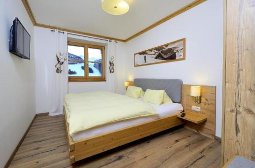 un dormitorio con una cama y una ventana en Bachgut, das Resort am Berg - Stammhaus Winter, en Saalbach Hinterglemm