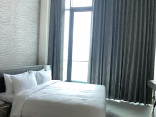 a bedroom with a white bed and a large window at Sunday Hotel & Residences Gurugram in Gurgaon