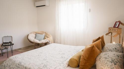 a bedroom with a bed and a chair at Pâquerette in Arles