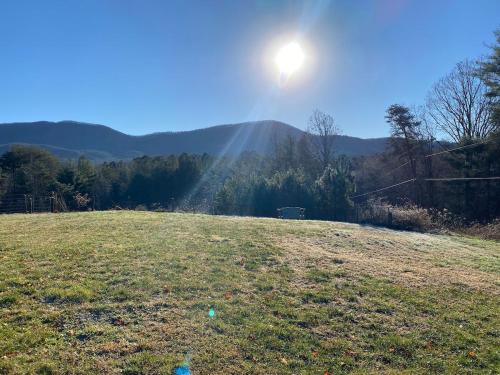 a field with the sun shining in the distance at The Lodge at Coker Creek in Coker Creek