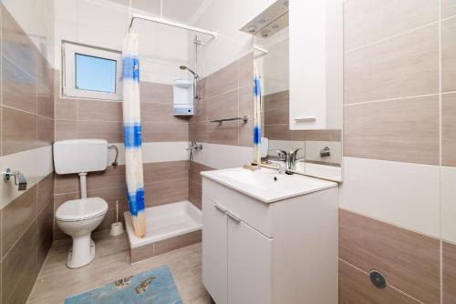a bathroom with a toilet and a sink and a shower at Apartments Milorad M in Lopar