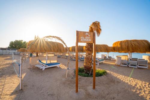 a beach with umbrellas and chairs and the ocean at Seven Seas Jolie Bay - Ultra All Inclusive in Hurghada