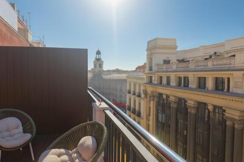 a balcony with chairs and a view of a city at Petit Palace Puerta del Sol in Madrid
