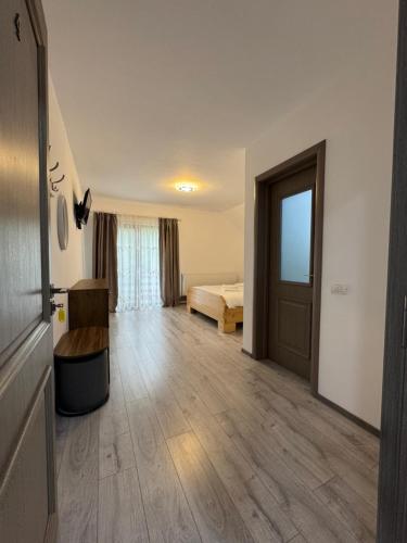 a large room with a bed and a door at Casa Abrudan in Scrind-Frăsinet