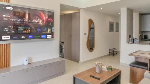 a living room with a tv on a wall at Breathtaking Sea View Retreat by Hala Homes in Ras al Khaimah