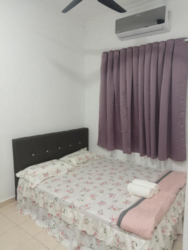 a bedroom with a bed with a flowery bedspread at FMS Homestay in Changlun