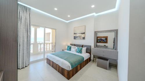 a bedroom with a bed and a flat screen tv at Breathtaking Sea View Retreat by Hala Homes in Ras al Khaimah
