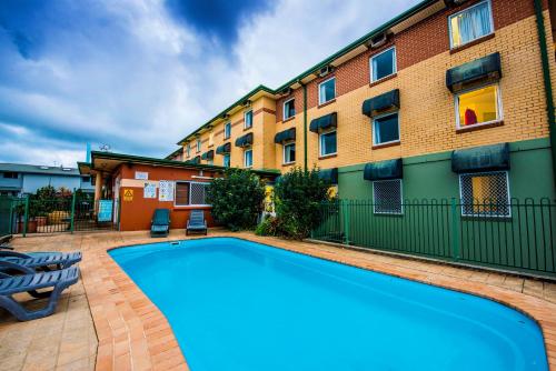 a swimming pool in front of a building at ibis Budget Coffs Harbour in Coffs Harbour