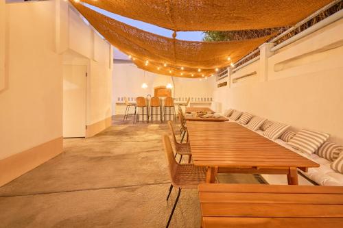 a dining room with wooden tables and chairs at Wander Surf House in Santa Cruz