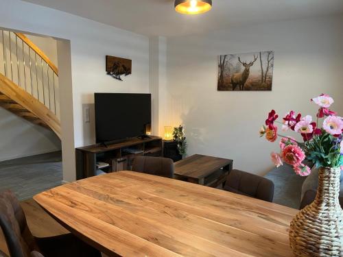 a dining room with a table and a vase with flowers at Appartements Bergliebe in Bichlbach