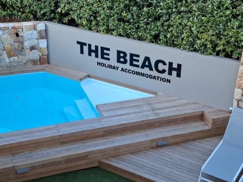 a sign for the beach with a swimming pool at Beach Holiday Accommodation in Hout Bay
