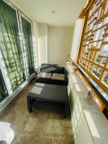 two beds in a room with large windows at Luxury Apartments at Goldcrest Mall and Residency DHA Phase 4 by Nirvana Nests in Lahore