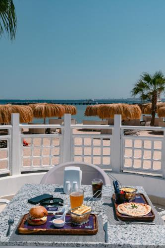 a table with food and drinks on a table on the beach at Seven Seas Jolie Bay - Ultra All Inclusive in Hurghada