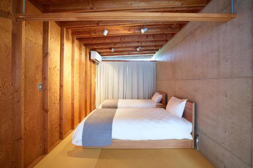 a bedroom with a bed in a room with wooden walls at Date Villa Awaji in Sumoto