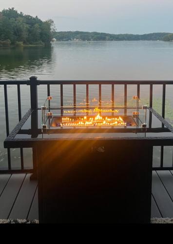 a fire pit sitting on a dock next to a body of water at Off the Hook in Newaygo