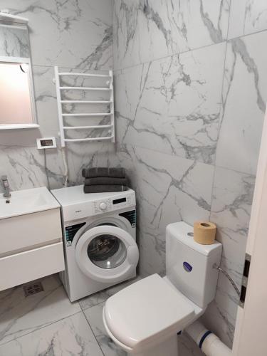 a bathroom with a toilet and a washing machine at LCB Apartments Universitate Suceava A59 in Suceava