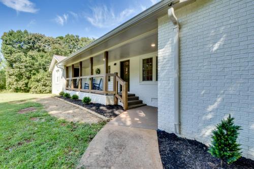 a white house with a porch and a deck at Quiet Countryside Getaway in Appalachian Foothills in Commerce