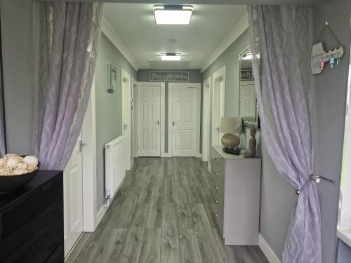 a hallway with wood floors and purple curtains at The Meadows in Market Drayton