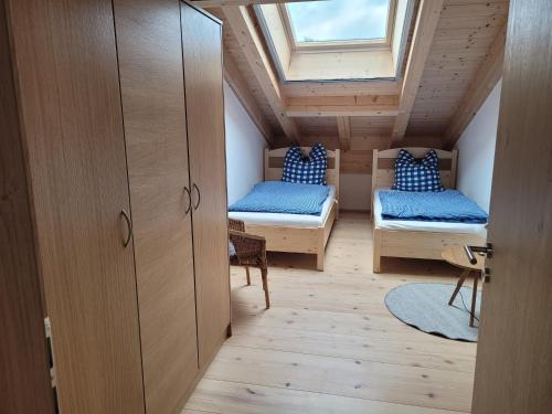 a attic room with two beds and a window at Urlaub in Benediktbeuern in Benediktbeuern