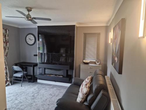 a living room with a couch and a television at The Meadows in Market Drayton