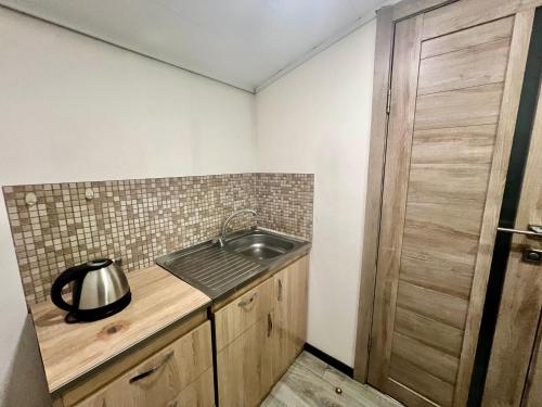 a kitchen with a sink and a wooden door at Campus Luxe Castle Hotel in Yerevan