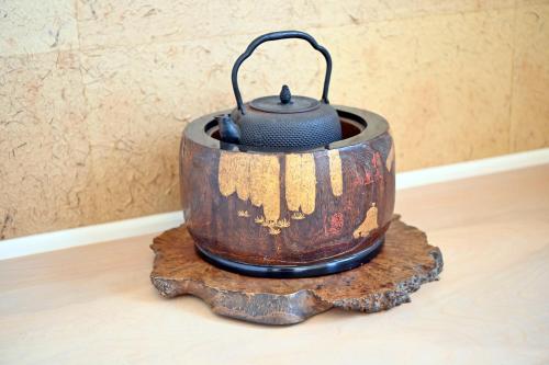 a pot sitting on top of a tree stump at Maccha House Near Zenkoji Nagano in Nagano