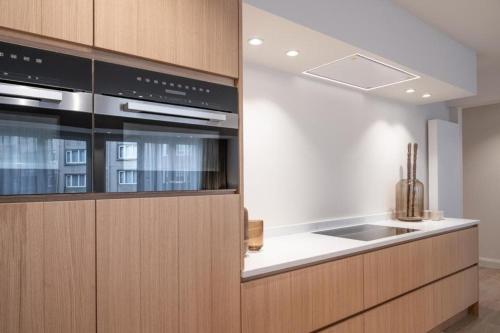 a kitchen with wooden cabinets and a sink at Luxurious Escape by the Sea in Knokke-Heist