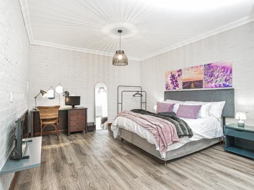 a bedroom with a bed and a desk and a television at Links & Lavender in Centurion