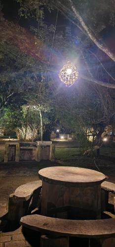 a table and bench in a park at night at Camping Tacuara in Independencia