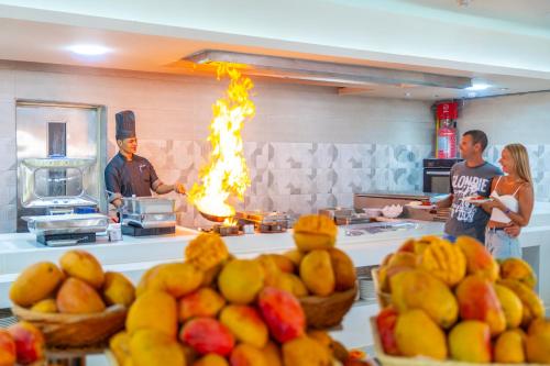 a group of people standing in a kitchen with fire at Seven Seas Jolie Bay - Ultra All Inclusive in Hurghada