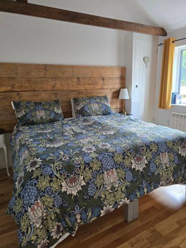 a bedroom with a bed with a colorful comforter at Willow Cottage in idyllic location in Kent