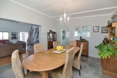 a dining room and living room with a wooden table and chairs at Hugo Haven in Bredasdorp