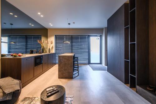 a kitchen with wooden cabinets and a counter top at Jacuzzi Cinema Japandi 2 in Kaunas