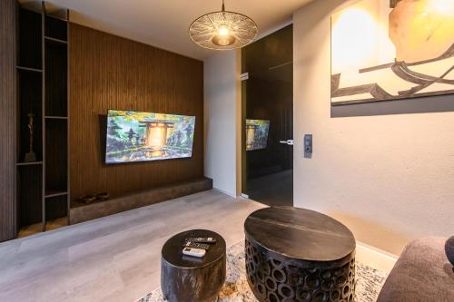 a living room with two stools and a tv at Jacuzzi Cinema Japandi 2 in Kaunas