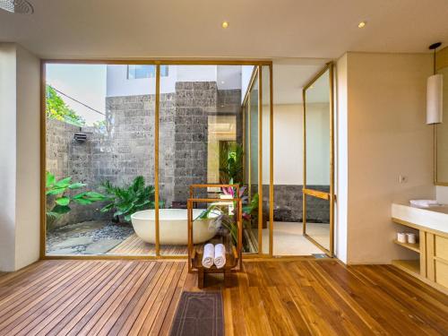 a bathroom with a tub and a large window at Narawangsa Villa 4br Amazing Sunset Rooftop in Kerobokan