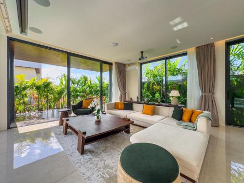 a living room with a couch and a table at Narawangsa Villa 4br Amazing Sunset Rooftop in Kerobokan