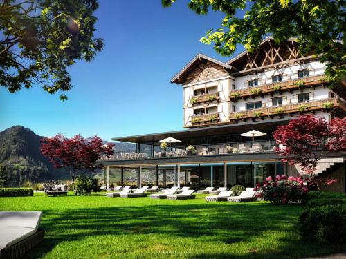 a hotel with a lawn in front of a building at Hotel Oberforsthof in Sankt Johann im Pongau